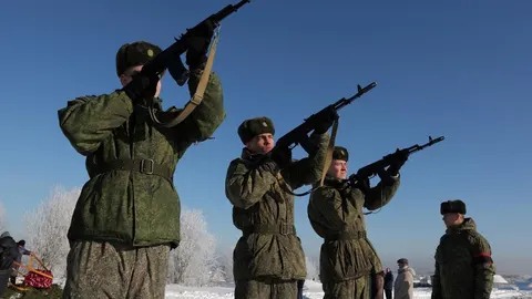Vojnici u maskirnim odorama pucaju iz pušaka na snijegu pod vedrim nebom.