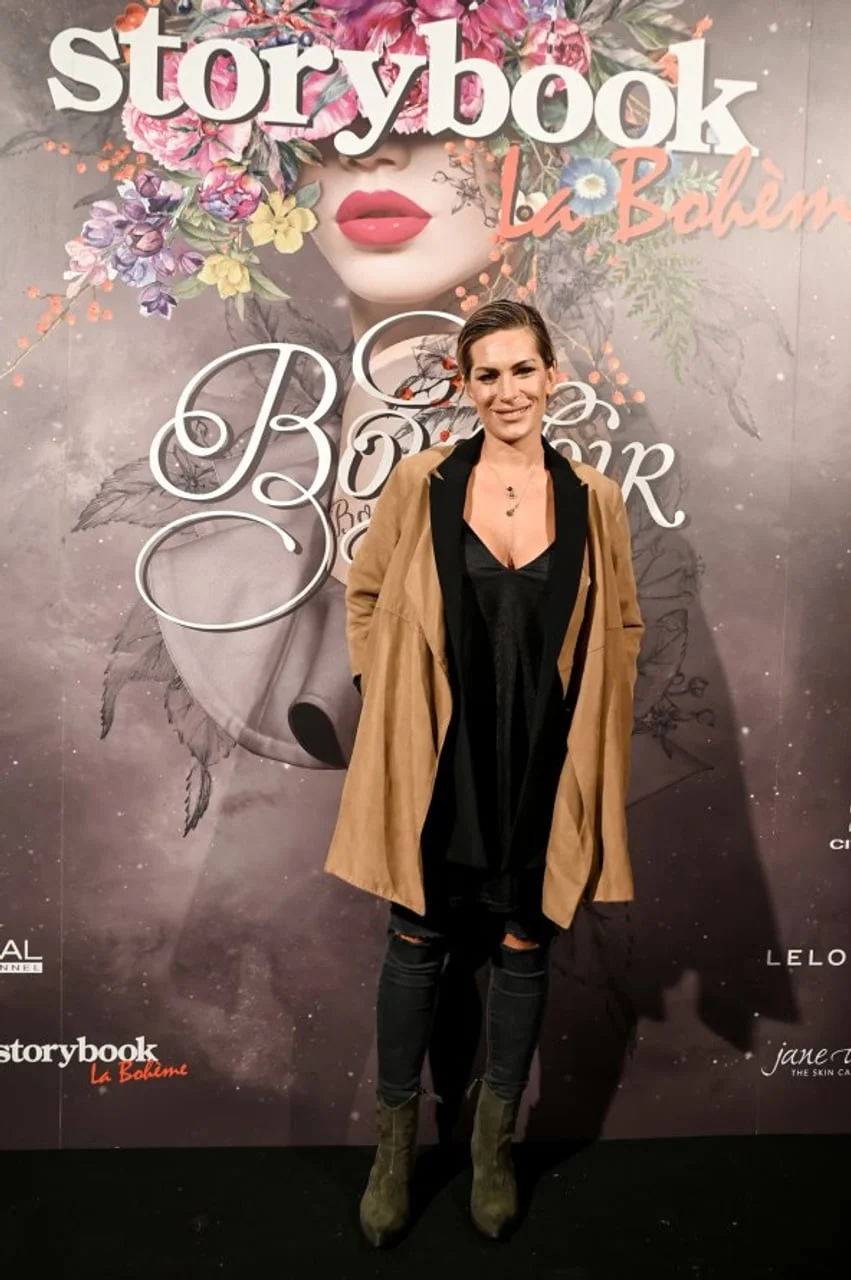 Nika Fleiss u bež kaputu pozira ispred promotivnog Storybook panoa.