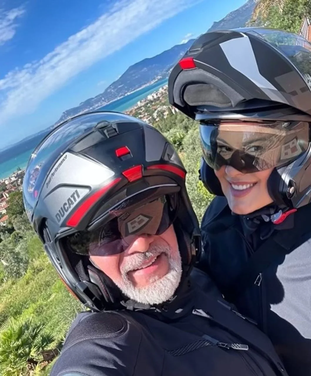 Indira Levak i Miroslav Levak s kacigama na motociklu uz more.