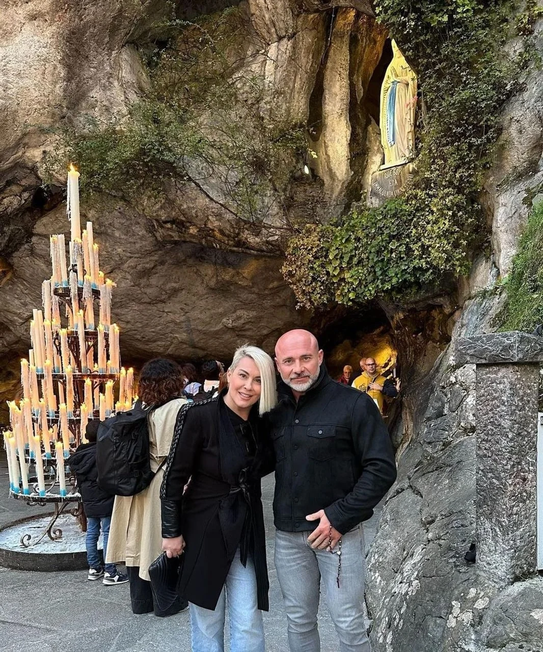 Miroslav i Indira ispred špilje s kipom Majke Božje i svijećama.