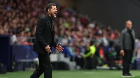 Diego Simeone u crnom odijelu gestikulira i viče uz rub nogometnog terena.