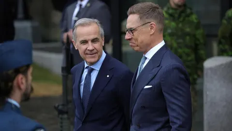 Mark Carney i Alexander Stubb stoje jedan pored drugoga u tamnim odijelima.