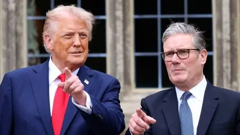 Donald Trump i Keir Starmer stoje jedan pored drugoga i pokazuju prstom prema naprijed