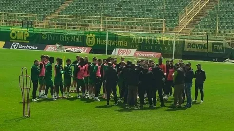 Grupa nogometaša i civila okupljena na travnjaku stadiona Aldo Drosina u Puli.