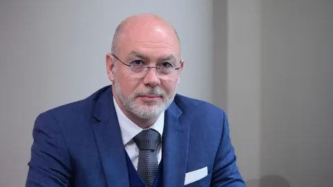 Siniša Krajač u plavom odijelu s naočalama gleda izravno u kameru.