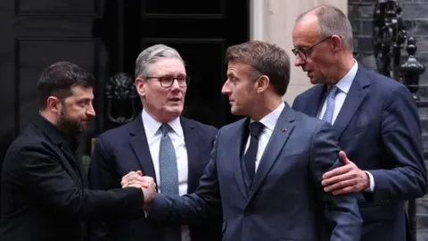 Europski lideri Zelenski, Starmer i Macron razgovaraju ispred službenog ulaza.