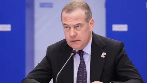 Dmitrij Medvedev u tamnom odijelu govori za mikrofonom na službenom skupu.