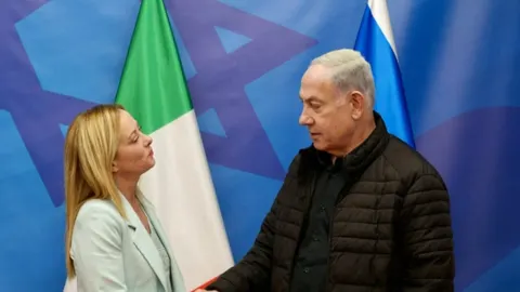 Giorgia Meloni i Benjamin Netanyahu razgovaraju ispred zastava Italije i Izraela.