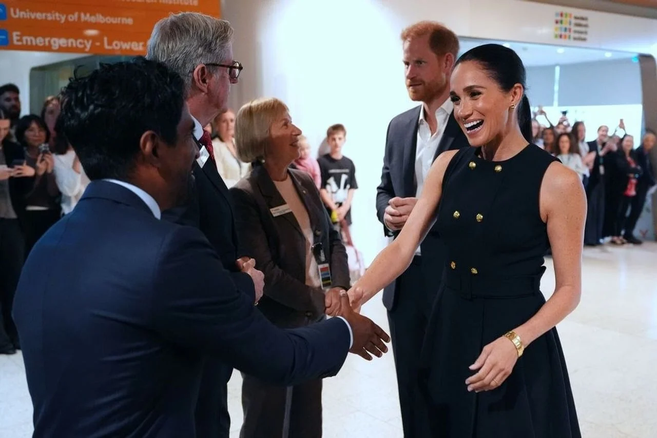 Meghan Markle se nasmijana rukuje s muškarcem u odijelu