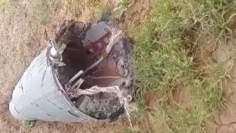 Metalni ostaci vojnog projektila na travnatom terenu u Siriji