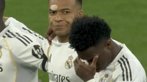 Kylian Mbappé i suigrači iz Real Madrida tijekom minute šutnje na terenu.