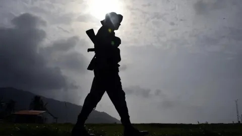 Silueta vojnika pod punom opremom nasuprot sunca