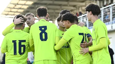 Mladi nogometaši Dinama u žutim dresovima slave postignuti pogodak na terenu.