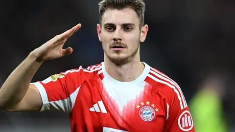 Josip Stanišić u dresu Bayerna pozdravlja rukom uz čelo