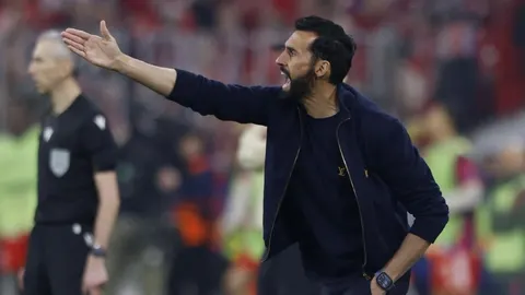 Álvaro Arbeloa u tamnoj jakni energično gestikulira rukom pored nogometnog terena.