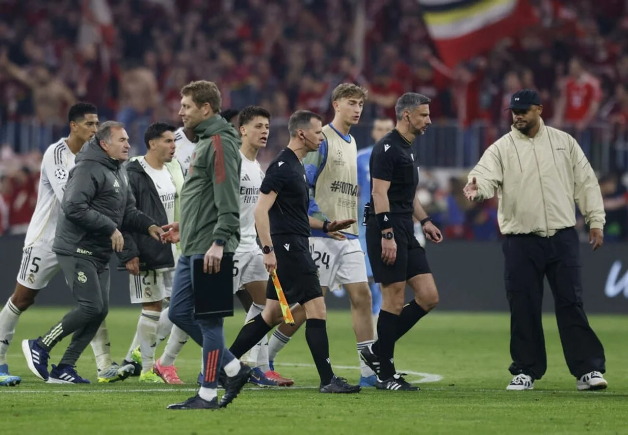 Igrači i stručni stožer Real Madrida raspravljaju sa sucima na nogometnom terenu.