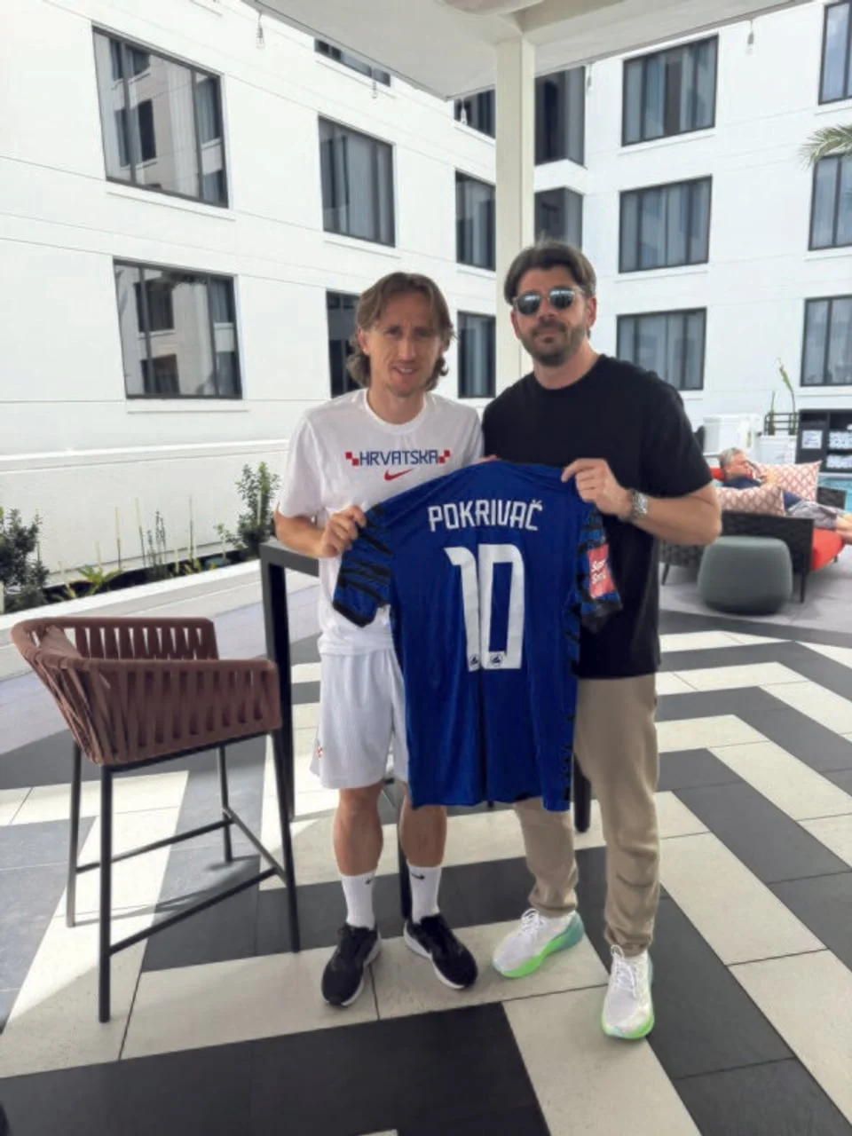 Luka Modrić i muškarac drže plavi nogometni dres s prezimenom Pokrivač