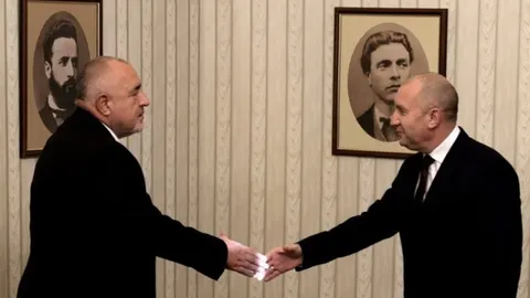 Rumen Radev rukuje se s političkim dužnosnikom ispred povijesnih portreta.