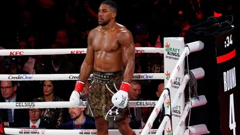 Anthony Joshua stoji u ringu s boksačkim rukavicama tijekom borbe.