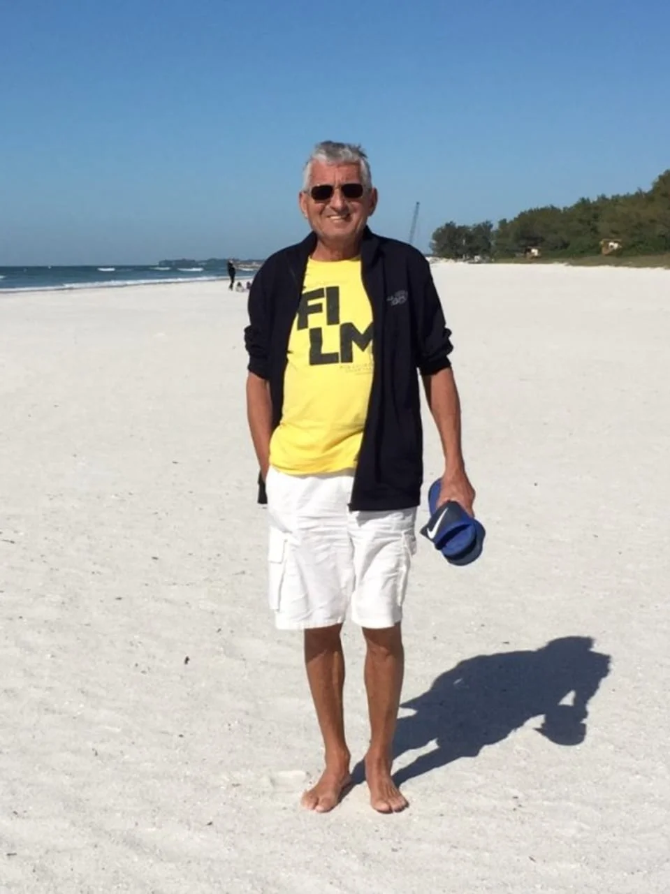 Glumac Otokar Levaj u žutoj majici stoji bos na pješčanoj plaži