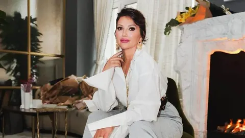 Nina Badrić sjedi u elegantnoj bijeloj košulji pored kamina