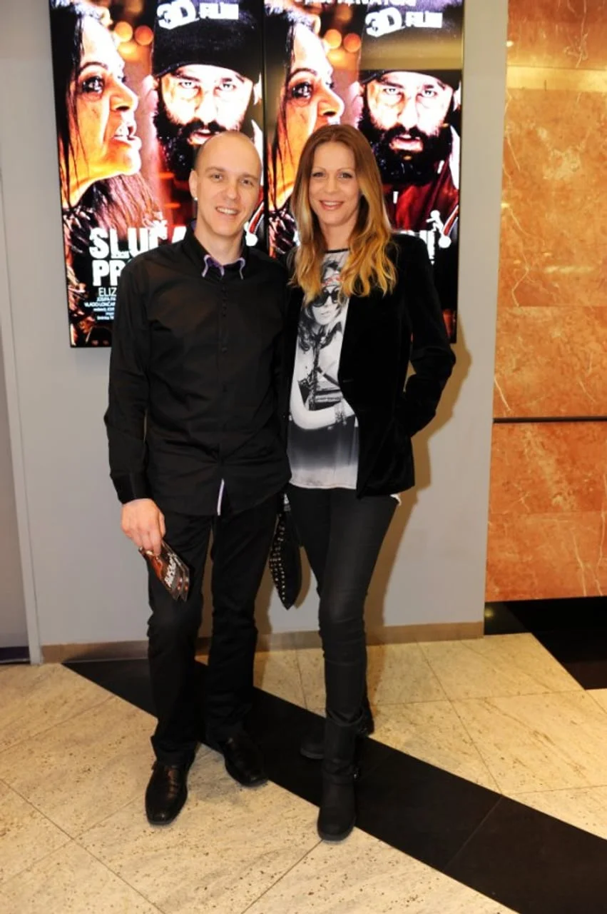 Par pozira ispred filmskog plakata u kinu