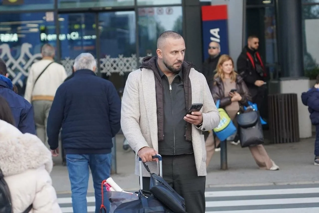 Dado Polumenta na ulici s putnim torbama i mobitelom u ruci