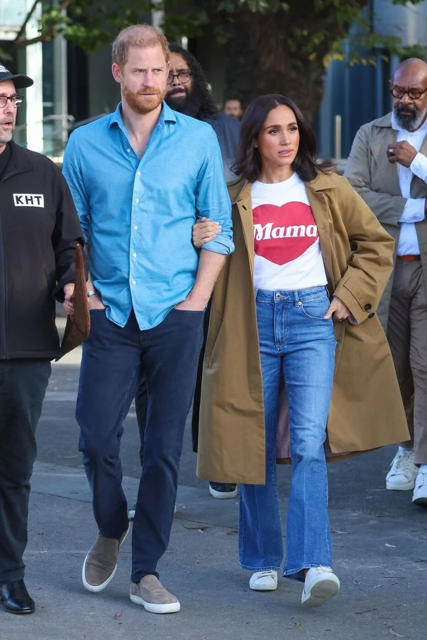 Meghan Markle u bijeloj majici s natpisom Mama i žvutoj kabanici