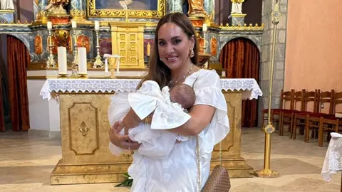 Simona Mijoković drži bebu u naručju ispred crkvenog oltara