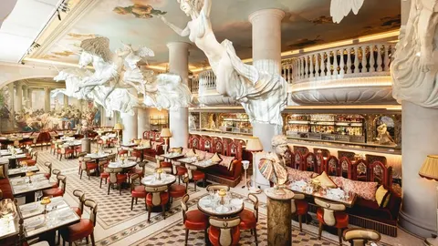 Luksuzni interijer prestižnog londonskog restorana s antičkim skulpturama i freskama.