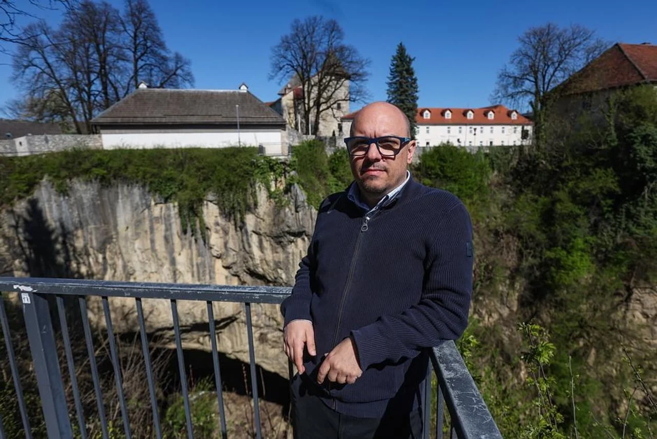 Muškarac s naočalama stoji na vidikovcu iznad dubokog kanjona rijeke Dobre.