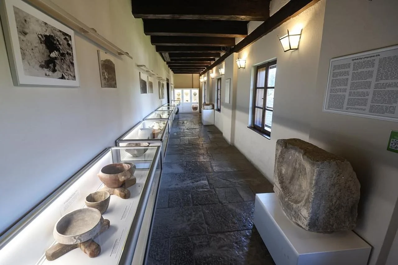 Muzejski hodnik s izloženim antičkim posudama i kamenim spomenicima.