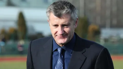 Marko Babić u tamnom odijelu i plavoj košulji na nogometnom stadionu.