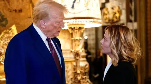 Donald Trump i Giorgia Meloni razgovaraju licem u lice u raskošnom interijeru.