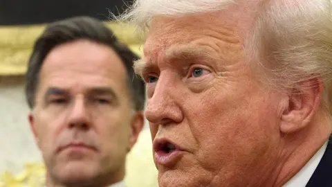 Donald Trump govori dok Mark Rutte stoji u pozadini tijekom sastanka.