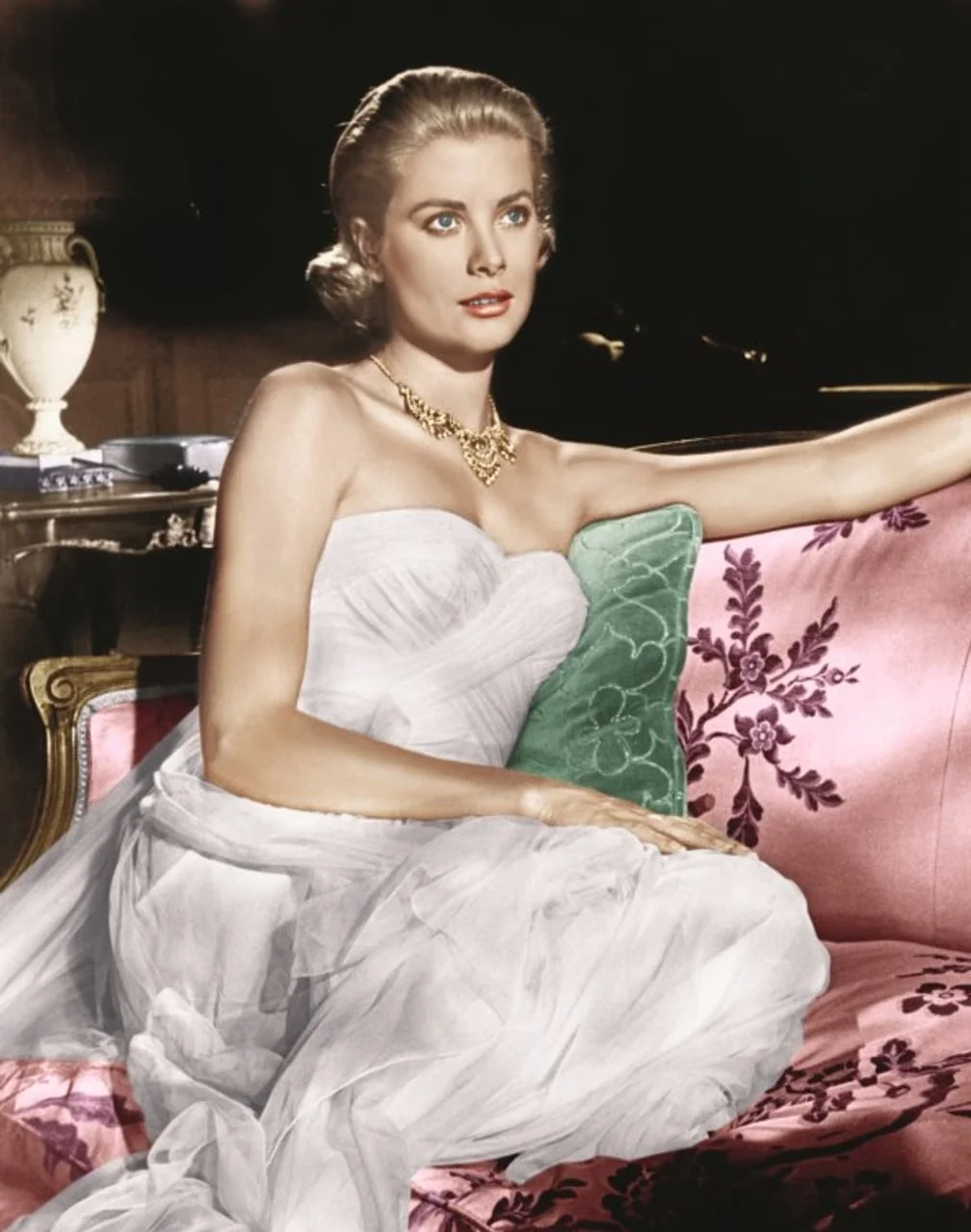 Grace Kelly sjedi na ružičastoj sofi u elegantnoj bijeloj haljini
