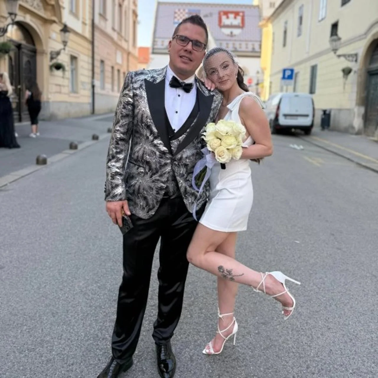 Luka Vidović u srebrnom odijelu i supruga poziraju na ulici