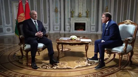 Aleksandar Lukašenko sjedi u fotelji tijekom intervjua u svečanoj dvorani.