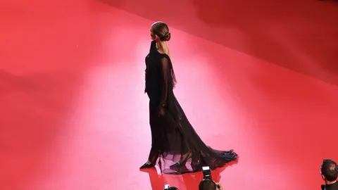 Manekenka Rouzi Hantington Vajtli u crnoj haljini na crvenom tepihu.