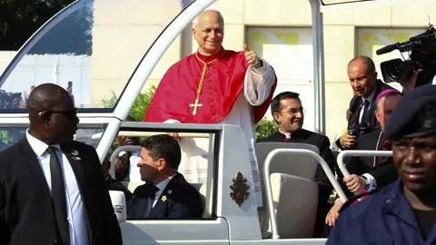 Papa Lav XIV u papamobilu pozdravlja okupljene vjernike s podignutim palcem.