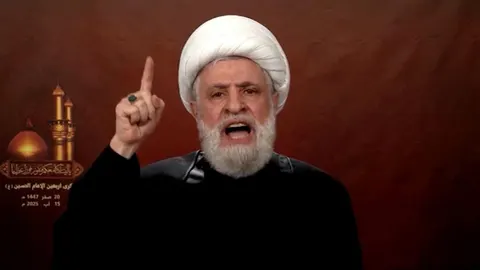 Naim Qassem s bijelim turbanom i podignutim prstom tijekom govora