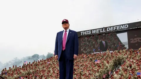 Donald Trump stoji na pozornici ispred velikog broja vojnika u uniformama.