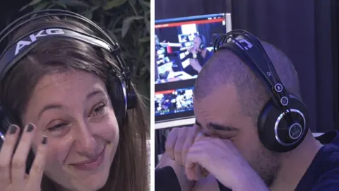 Radijski voditelji sa slušalicama plaču u studiju tijekom emisije.