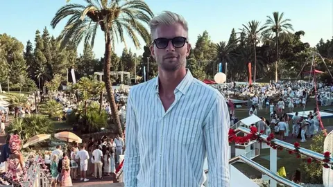 Ruben Van Gucht u prugastoj košulji s naočalama ispred palmi