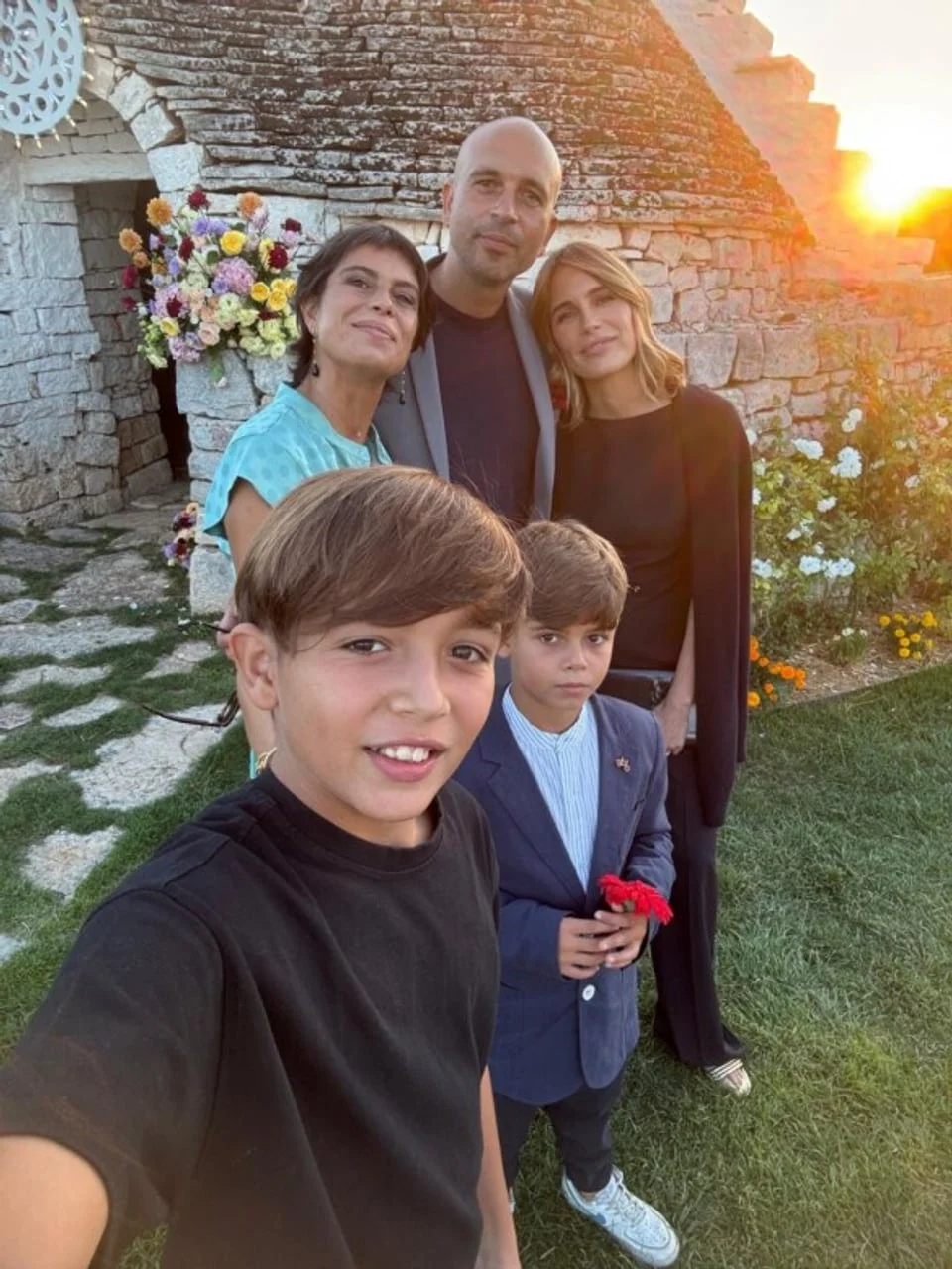 Obiteljska fotografija ispred kamene kuće uz zalazak sunca