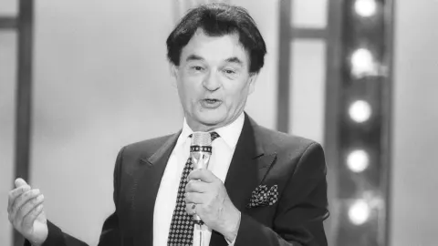 Crno-bijeli portret Ive Robića s mikrofonom u ruci tijekom nastupa.