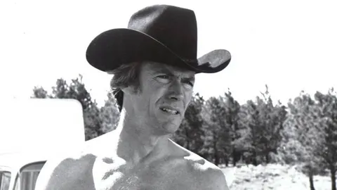 Mladi Clint Eastwood s kaubojskim šeširom u crno-bijeloj tehnici
