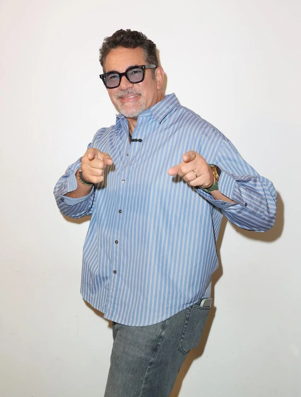 Eduardo Santamarina u prugastoj plavoj košulji s naočalama pozira i pokazuje prstima.
