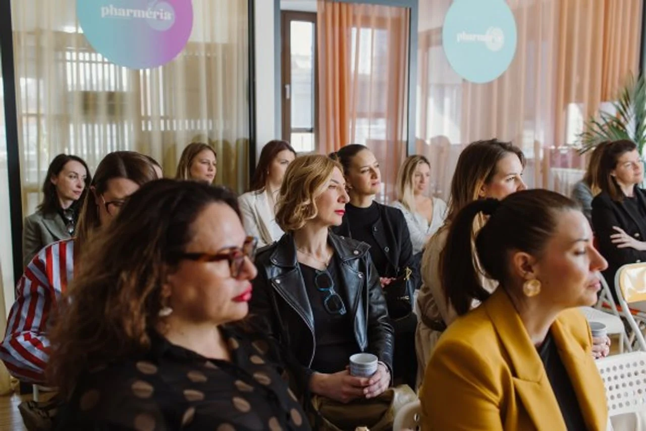 Publika sastavljena od žena pažljivo prati predavanje u dvorani.