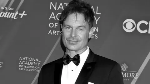 Crno-bijeli portret glumca Patricka Muldoona u svečanom odijelu s leptir mašnom.